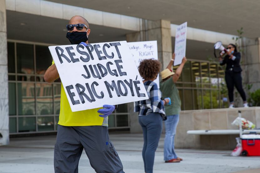 Protesters in support of Judge Eric Moye hold signs outside of the George Allen Civil Courts...