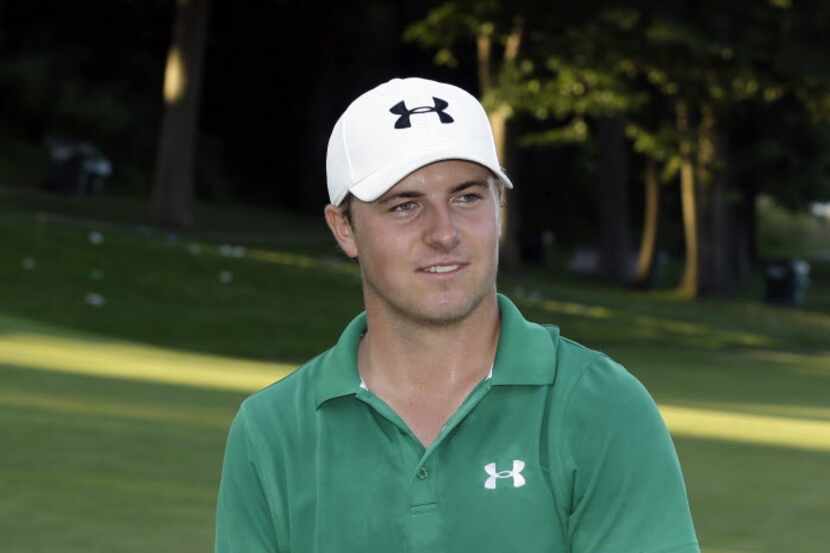 Jordan Spieth holds the John Deere Classic championship trophy, becoming the first teenager...