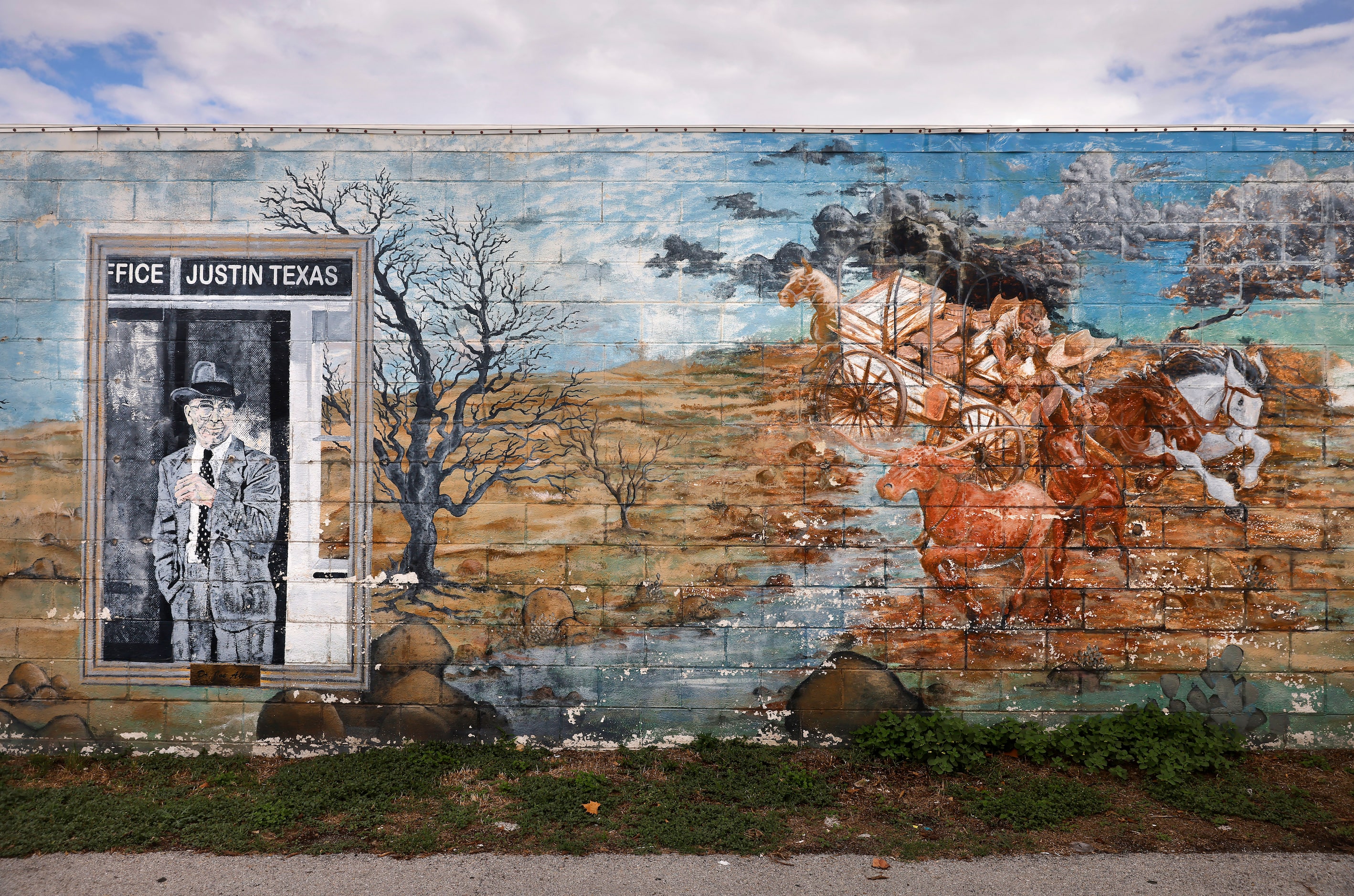 Weathered murals line the wall of a business in downtown Justin.