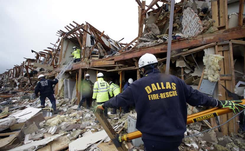 A Dallas firefighter looks for survivors trapped in an apartment destroyed when a fertilizer...