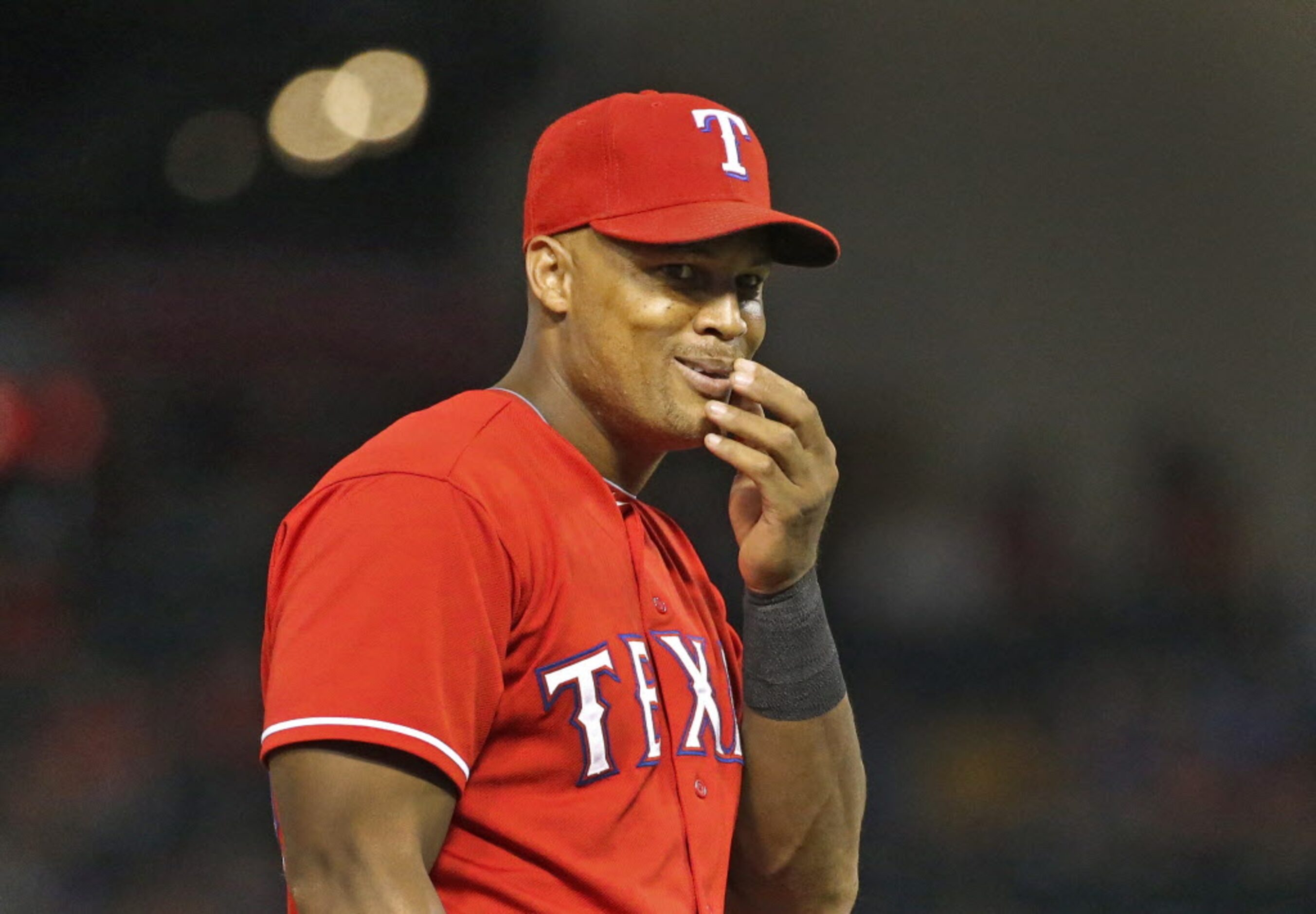 Texas third baseman Adrian Beltre jokingly gesture to the Athletics dugout after fielding a...