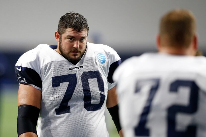 Dallas Cowboys guard Zack Martin (70) looks at Dallas Cowboys center Travis Frederick (72)...