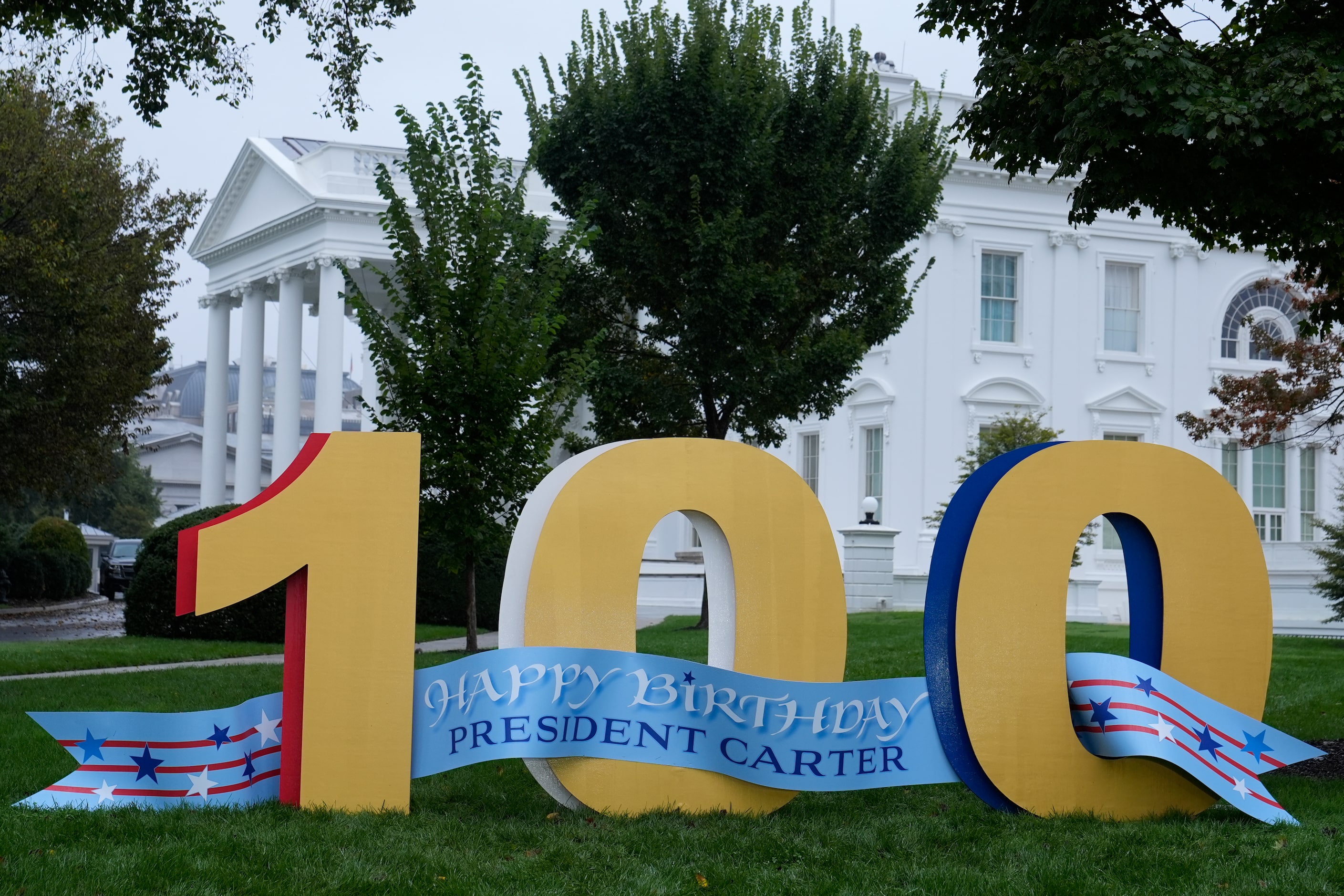 A sign wishing former President Jimmy Carter a happy 100th birthday sits on the North Lawn...