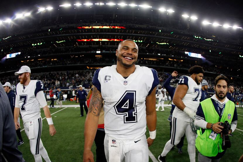Dallas Cowboys quarterback Dak Prescott (4) smiles as he walks off the field after their NFL...