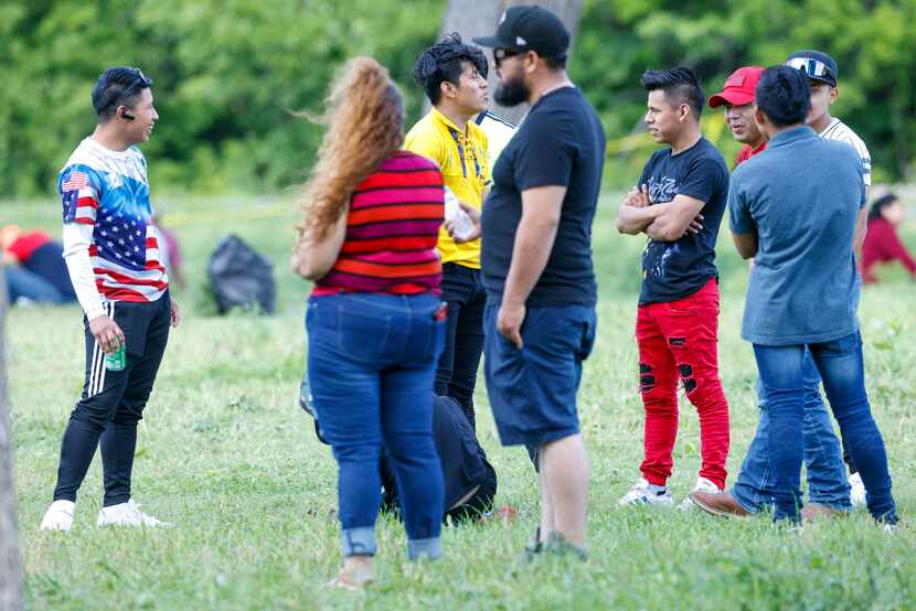 Family and friends of two men who are believed to have drowned stand near the Elm Fork of...