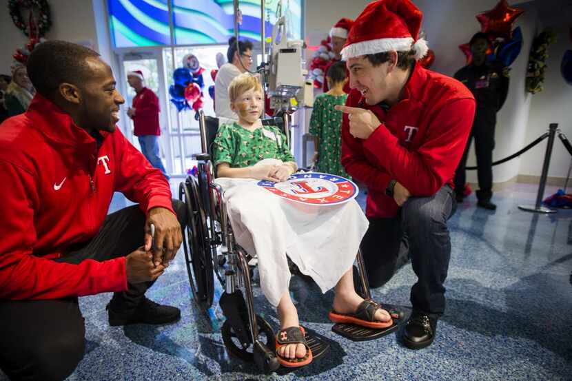 Texas Rangers pitcher Derek Holland (right) and  outfielder James Jones chat with patient...