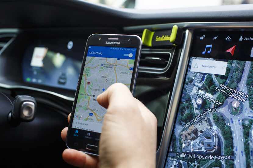 An Uber Technologies Inc. driver uses the company's smartphone app in a Tesla Motors Inc....
