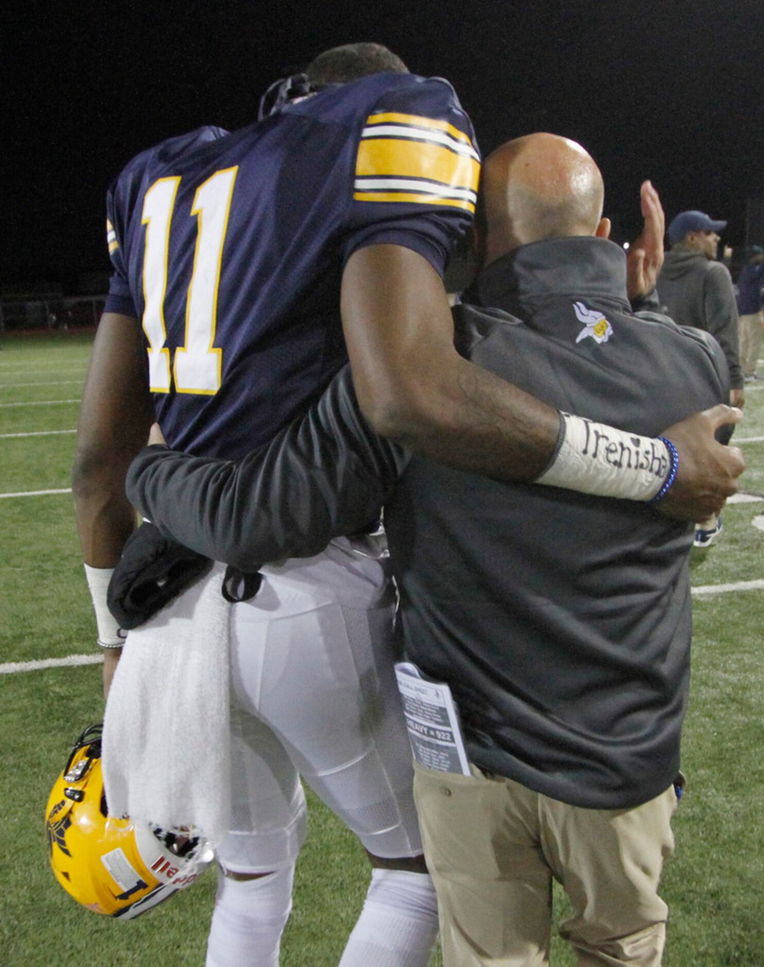 Arlington Lamar head coach Laban DeLay shares a consoling hug with Vikings receiver Cam...