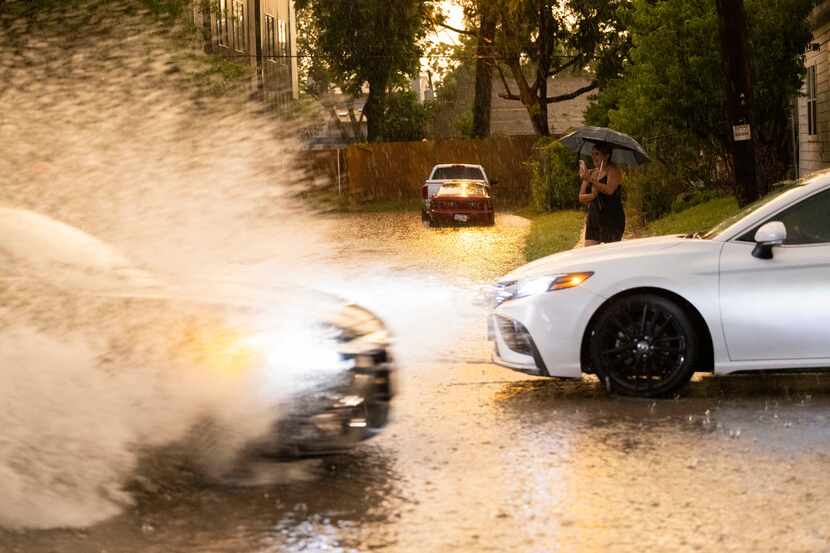 A staff photo of cars driving through water on streets in Dallas.