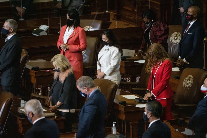 State representatives bow their head in prayer at the conclusion of the House opening...