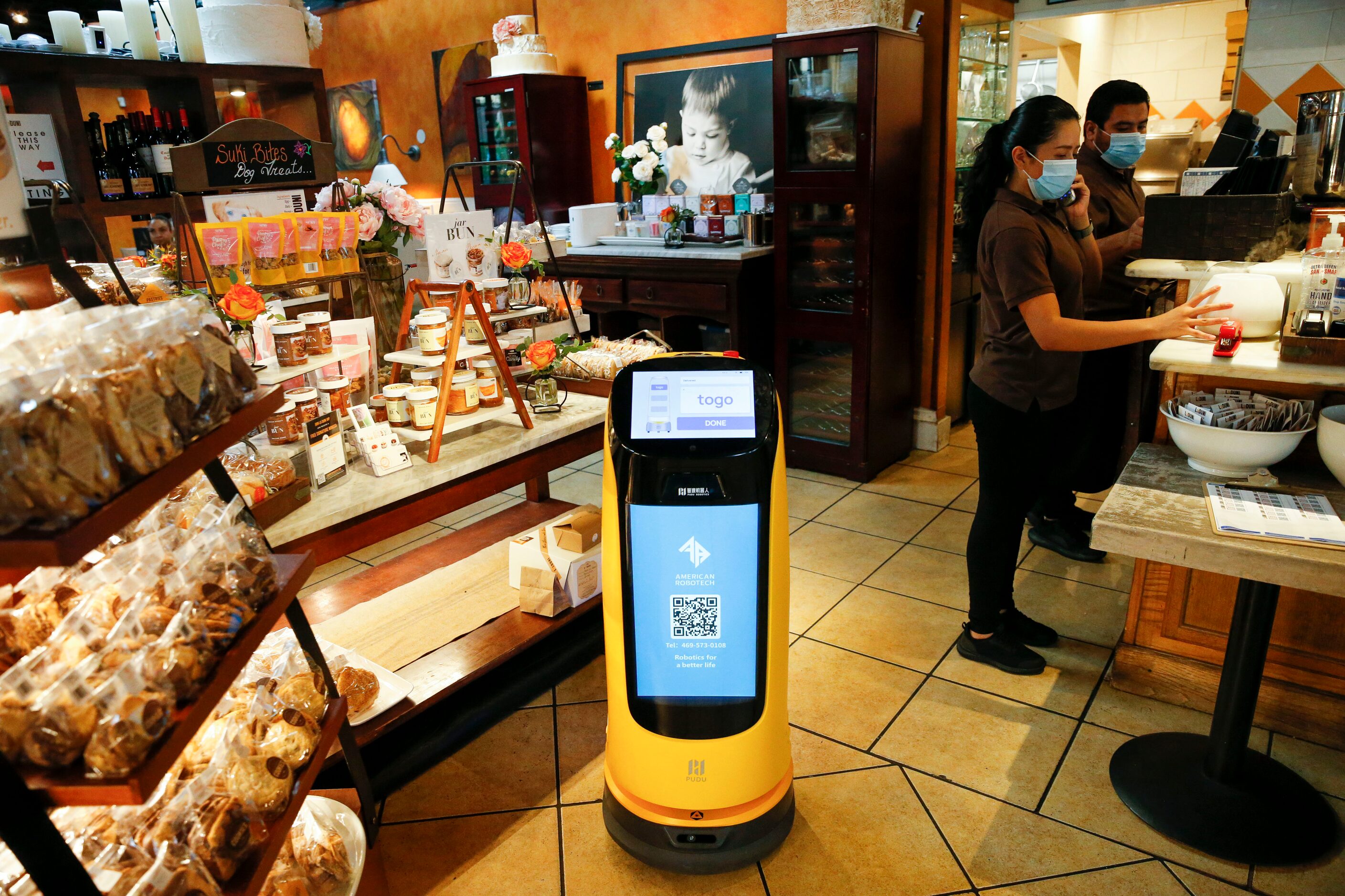 “Alexcita,” a beverage delivery robot, makes its way through La Duni Latin Cafe in 2021, in...