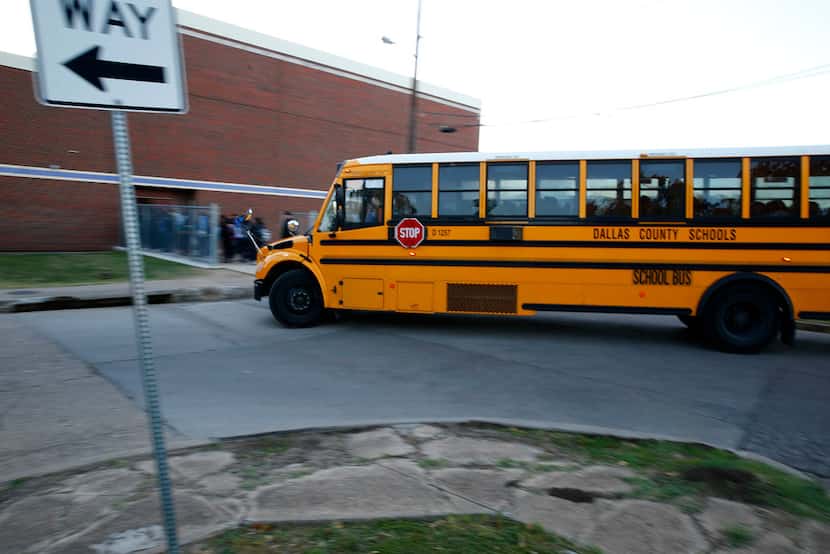 A school bus drops off students off at W.E. Greiner Exploratory Arts Academy in Dallas.