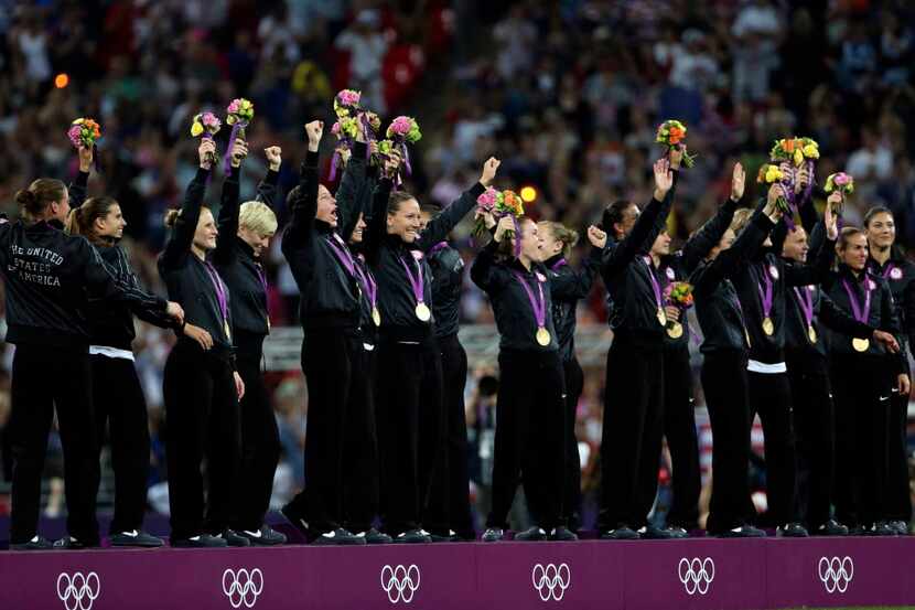 USA's women's soccer team celebrates with gold medals at the podium after defeating Japan at...