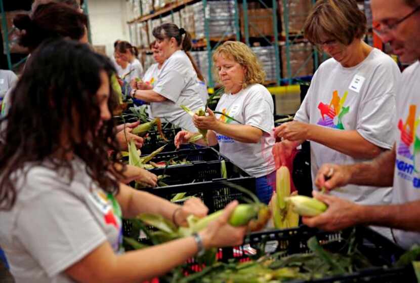 
Kate Ikeda (center) and other volunteers from PepsiCo shucked corn at the North Texas Food...