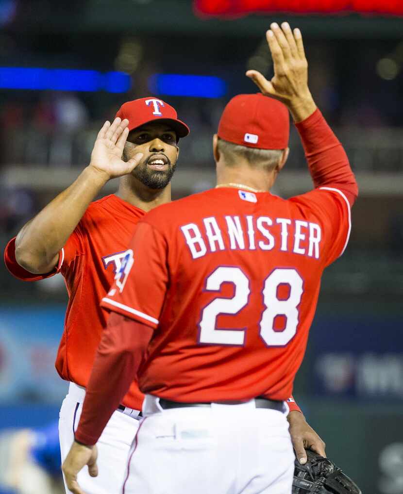 Texas Rangers outfielder Carlos Peguero gets a high five from manager Jeff Banister after a...