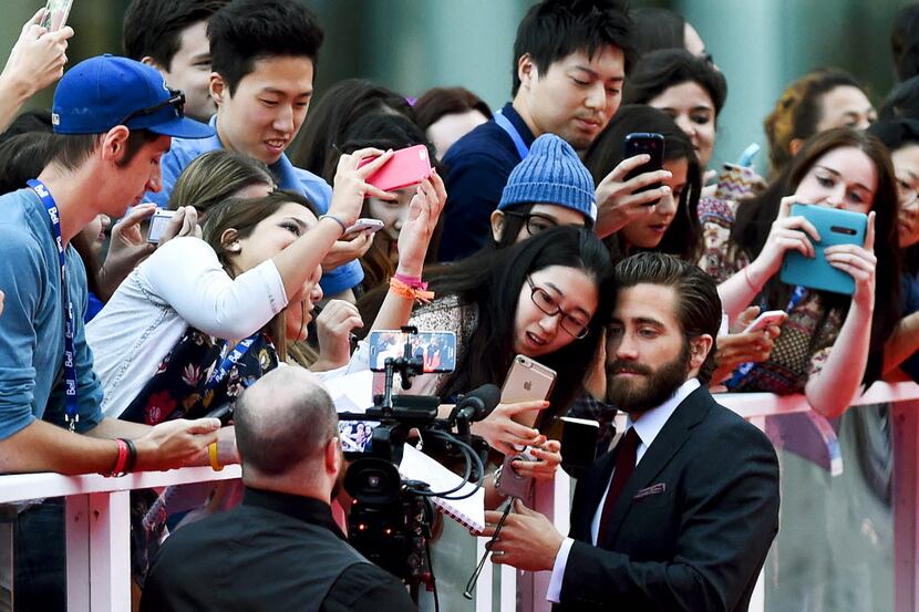 Actor Jake Gyllenhaal poses with a fan on the red carpet for the new movie "Demolition" on...