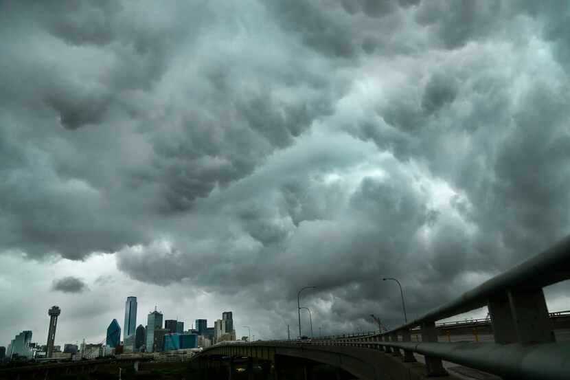  Dark storm clouds, seen near downtown Dallas, signify battles brewing between Texas...