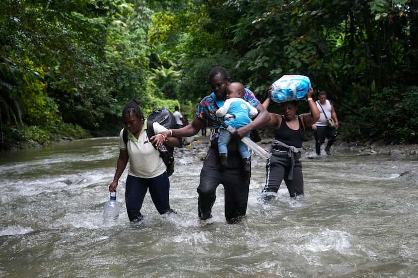Inmigrantes haitianos cruzan el Darién, de Colombia hacia Panamá, en su camino hacia Estados...