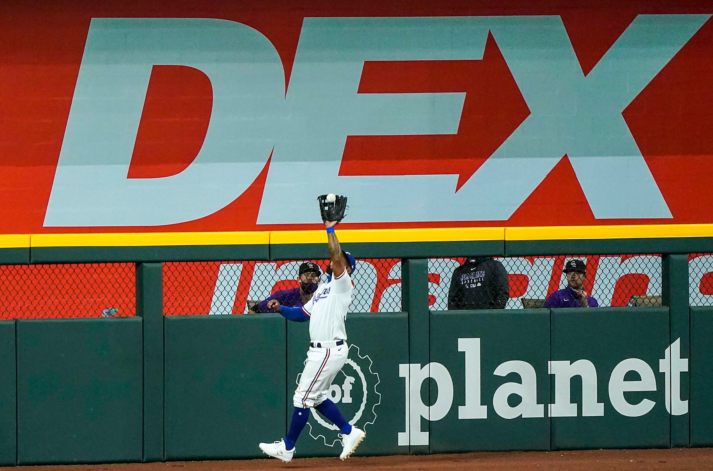 Texas Rangers outfielder Danny Santana makes a catch at the wall on a fly ball off the bat...