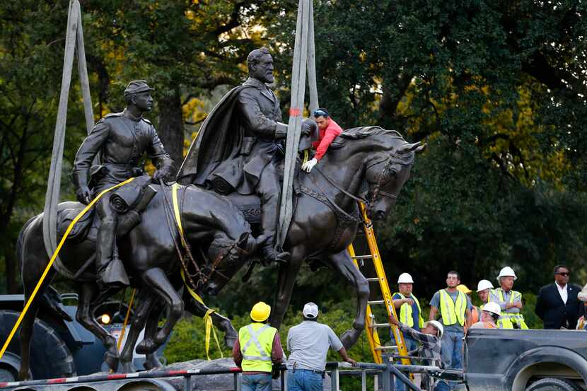 Workers harness the Robert E. Lee statue to a trailer for its removal from Robert E. Lee...
