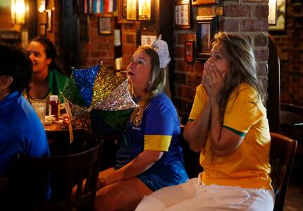 In 2018, Brazil fans Luciana Powell (center) Simone Pellizzi watch the  World Cup game...