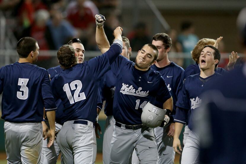 Wylie East Raiders first baseman Mitchell Clark (14) is met by teammates after hitting a...