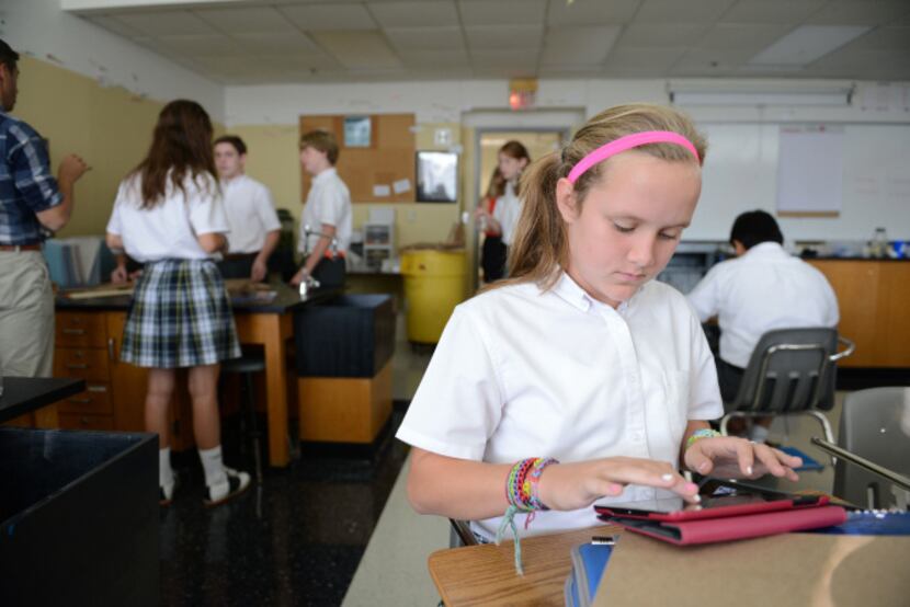 McKinley Lawson types on her iPad during Adam Willis' seventh-grade science class. Willis...
