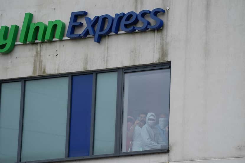 People watched from a window inside the Holiday Inn Express during a violent...