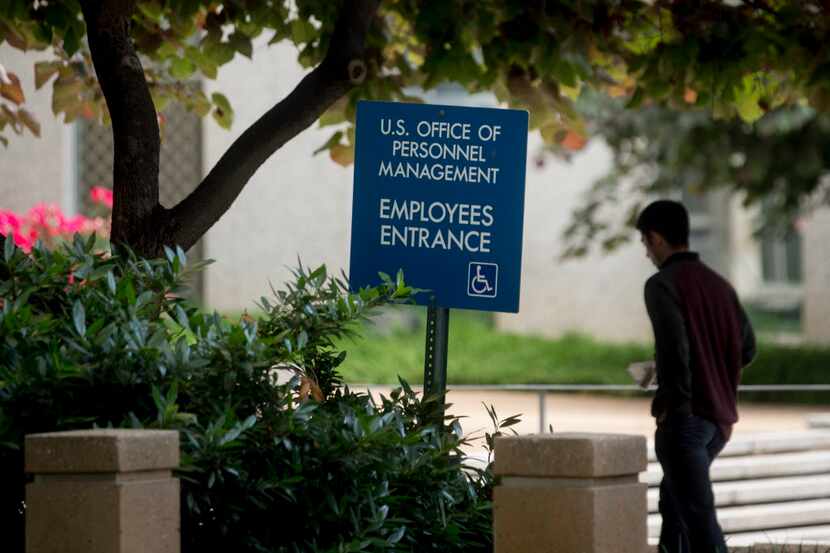 
A man walks past an employees entrance sign outside the Theodore Roosevelt Building,...