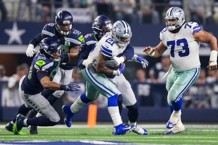 Dallas Cowboys running back Ezekiel Elliott (21) is tackled by Seattle Seahawks defenders...