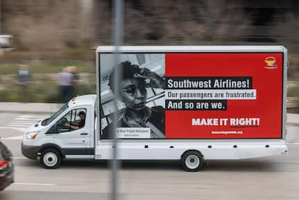 A truck with a protest billboard drives around the Dallas Love Field Airport during a...