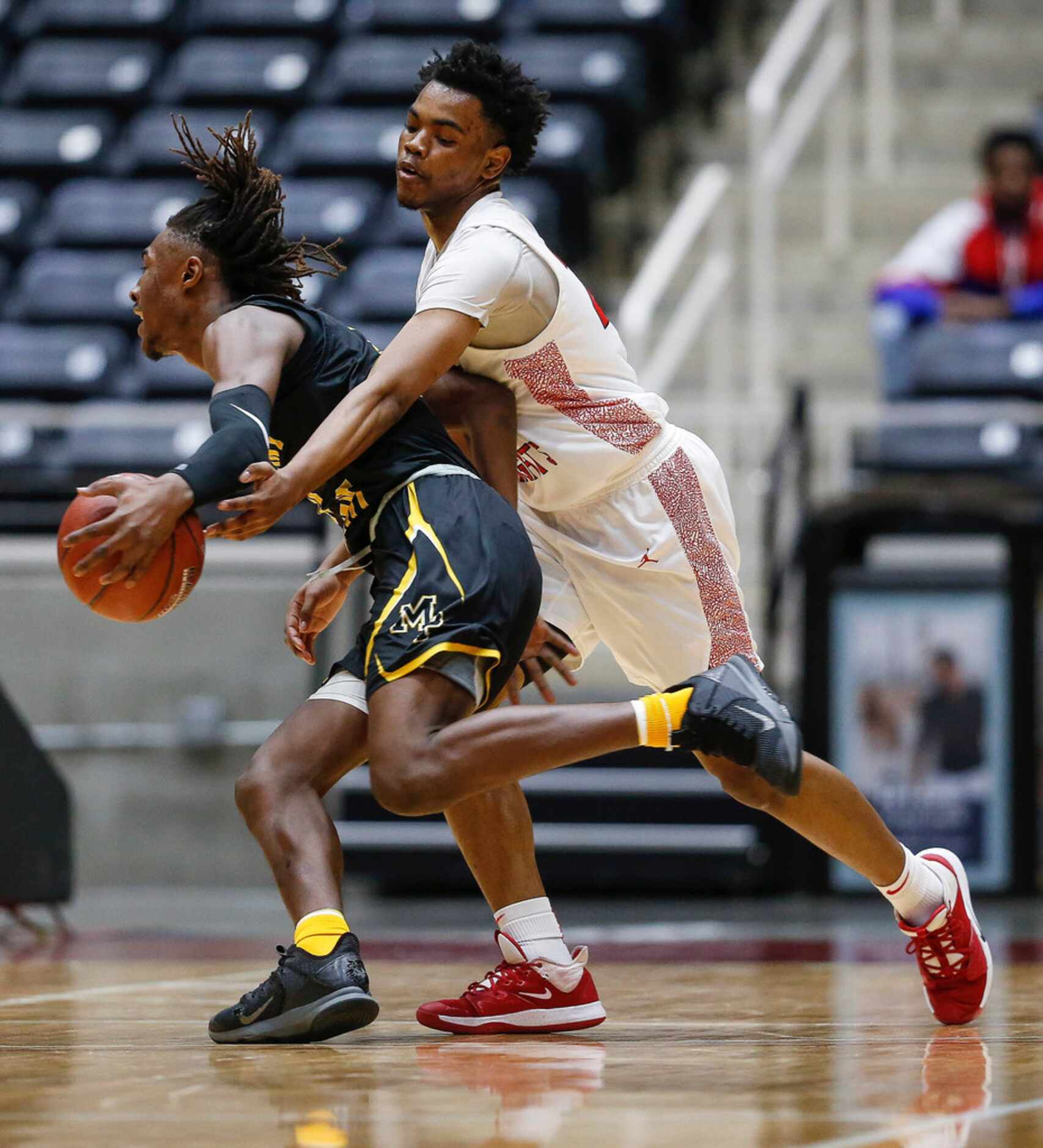 Kimball's Marcus Bonner (25) applies pressure as Mount Pleasant's Jamarion Brown (11) drives...