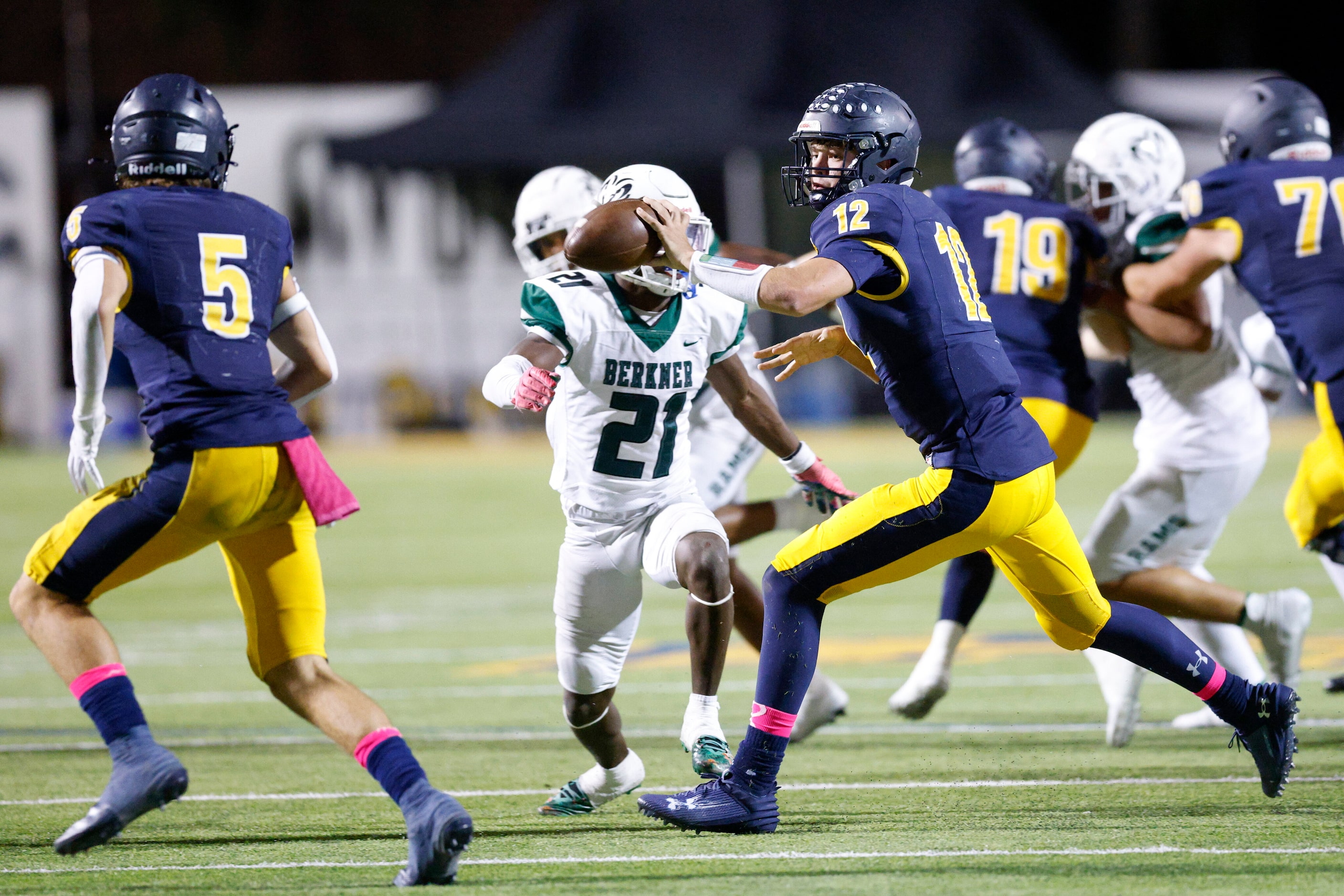 Highland Park quarterback Warren Peck (12) tosses the ball to running back Keller Holmes (5)...