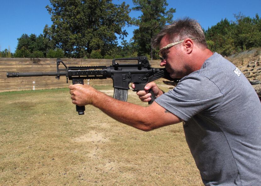 Shooting instructor Frankie McRae aims an AR-15 rifle fitted with a "bump stock" at his 37...