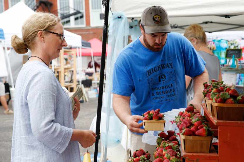 Bobby Bever bags some strawberries for Sarah Perry at the Highway 19 Produce & Berries booth...