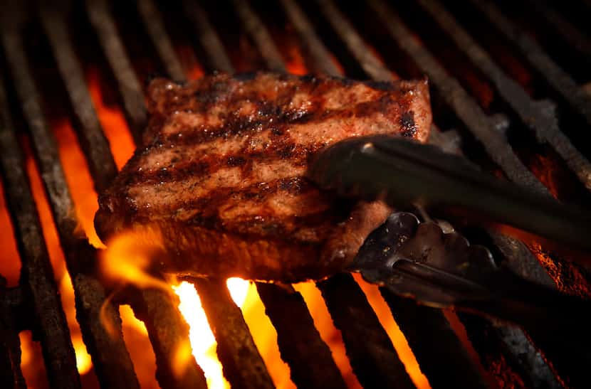 A sous vide flat iron steak is seared on a wood fired-grill at Knife Modern Steakhouse in...