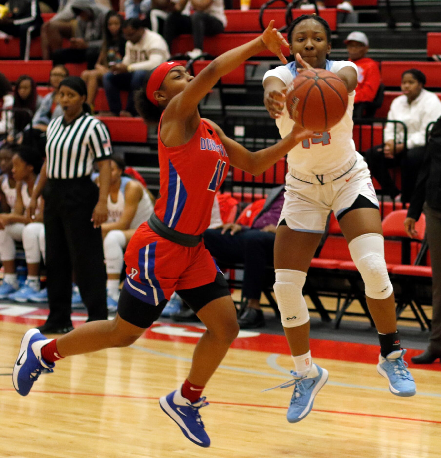 Duncanville's Tristen Taylor (11) battles Dallas Skyline's Daryn Batts (14) for a loose ball...