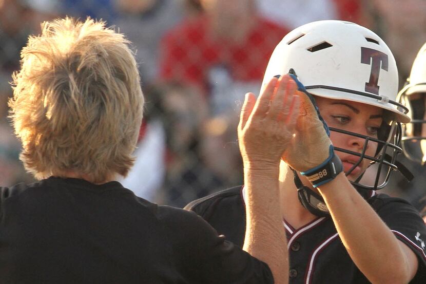 Mansfield Timberview outfielder Baylea Higgs (21) is congratulated by head coach Donya...