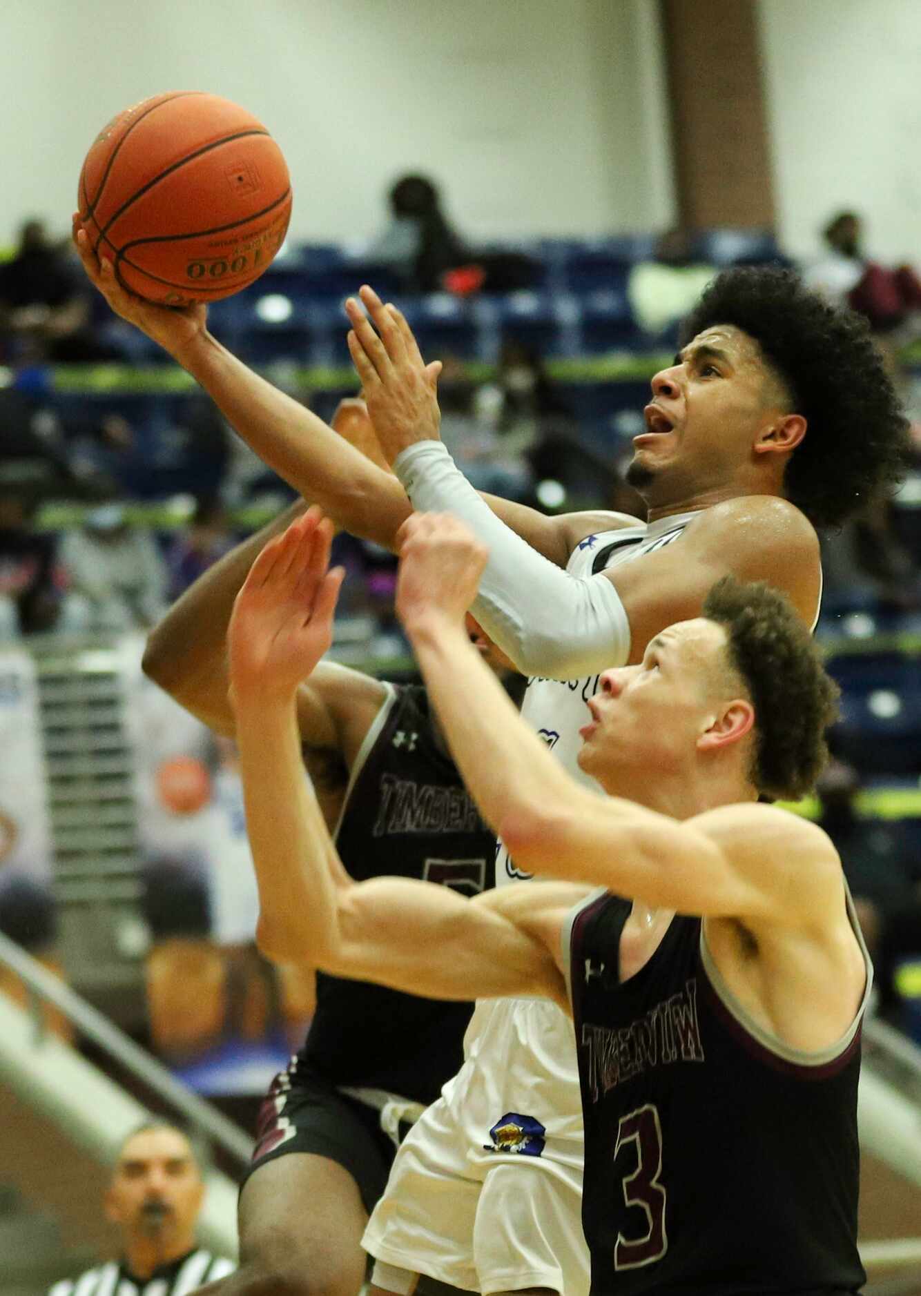 Mansfield Summit guard Channon Hall (11) attempts a layup over Mansfield Timberview guard...