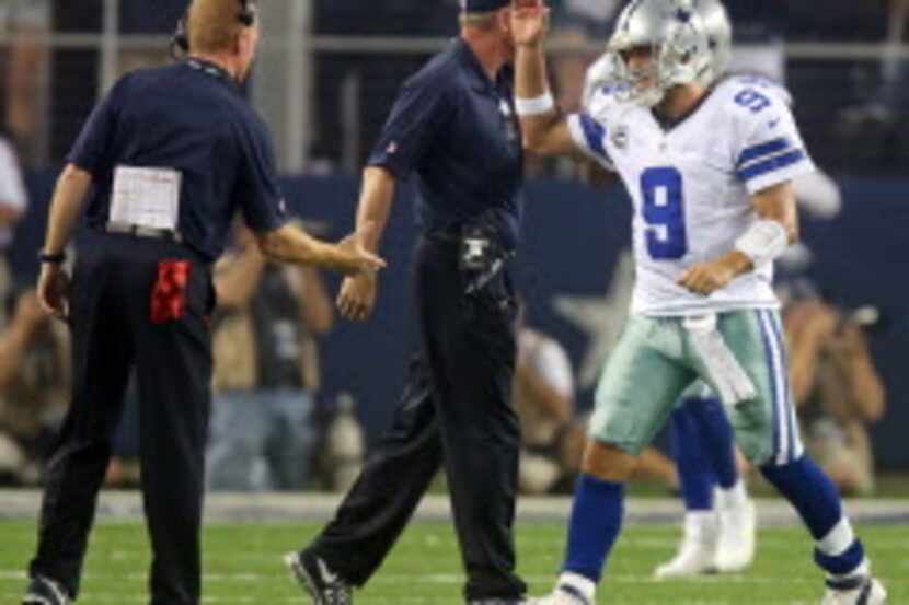 Dallas Cowboys quarterback Tony Romo (9) gets congratulated by head coach Jason Garrett...