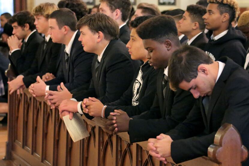 Bishop Lynch players kneel during mass, before Bishop Dunne and Bishop Lynch play each other...