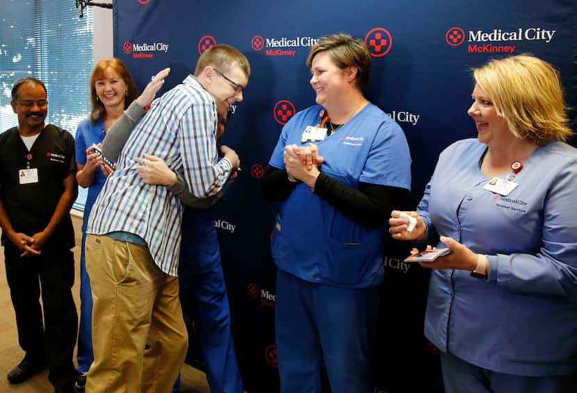 Caleb Johnson hugs Michelle Hooks, RN, ER director at Medical City Plano as others from the...