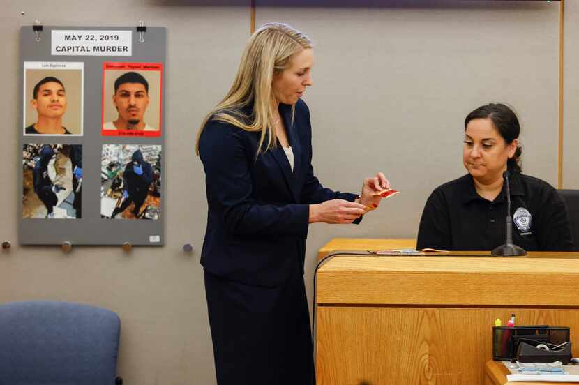 Prosecutor Caitlin Paver, left, shows evidence to Garland Police Department forensic...
