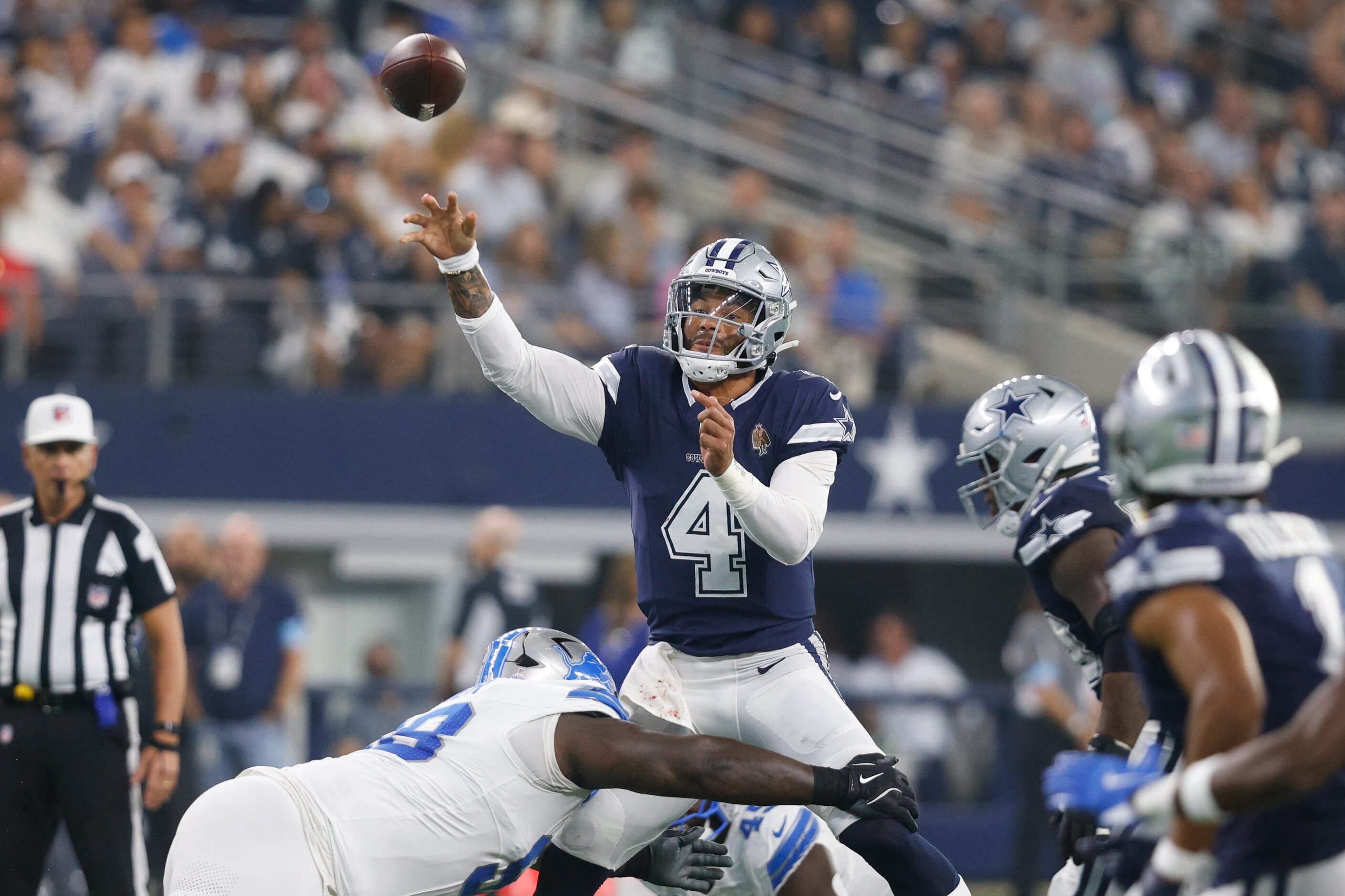 Dallas Cowboys quarterback Dak Prescott (4) passes under pressure from Detroit Lions...