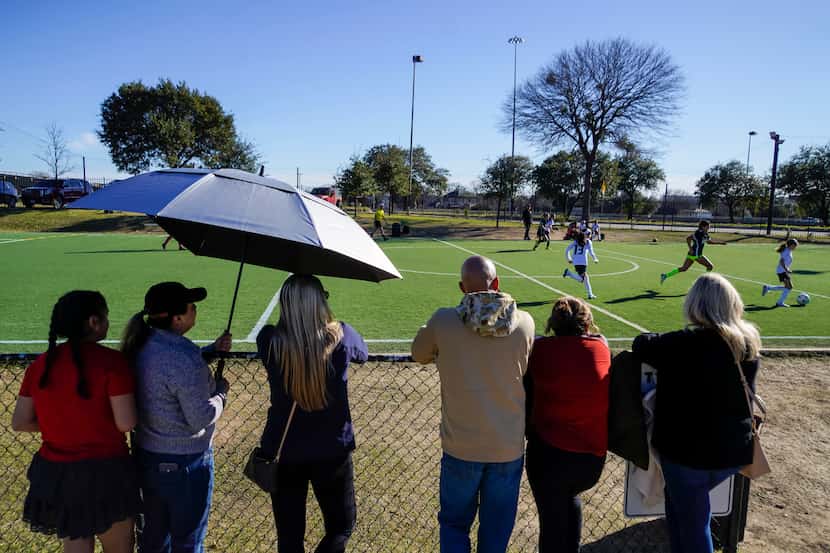 People watched young players compete in a game at the City Futsal soccer fields on a Sunday. 
 