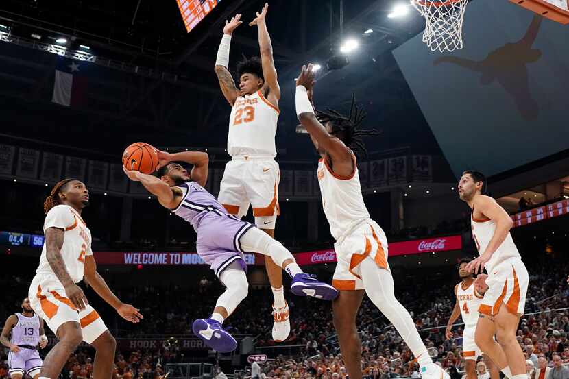 Kansas State guard Markquis Nowell, second from left, is fouled as he drives to the basket...