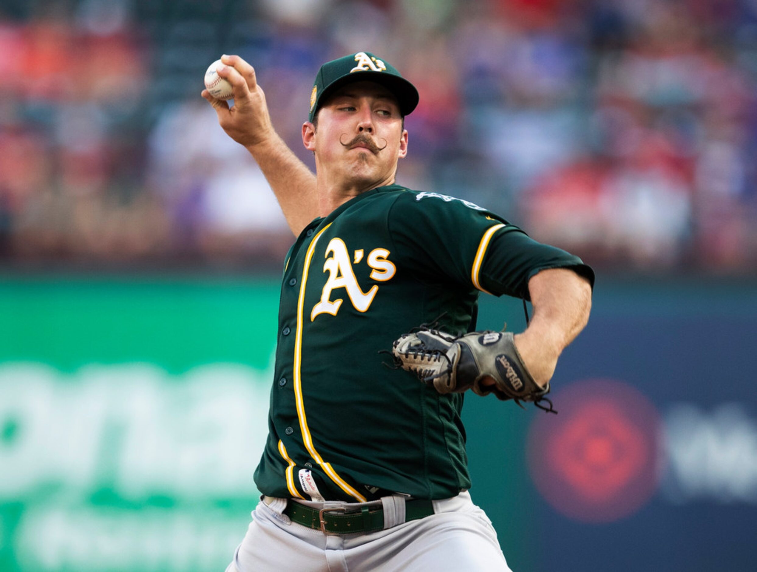 Oakland Athletics starting pitcher Daniel Mengden throws to a Texas Rangers batter during...