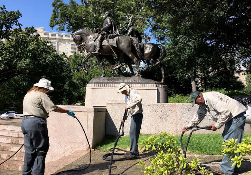 Dallas Parks department workers pack up after removing graffiti from the Robert E. Lee...