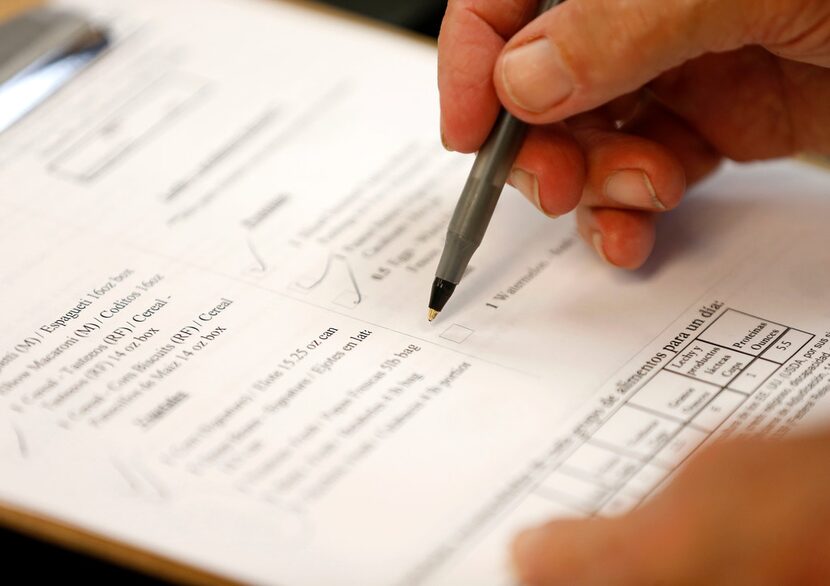 A volunteer goes through a check-list of items a client needs at Crossroads Community...