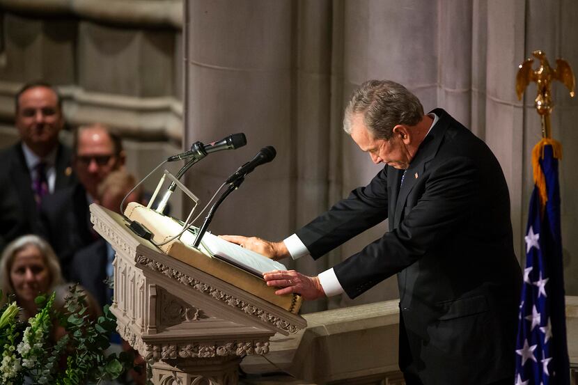 Former President George W. Bush composes himself as he delivers a eulogy during the State...